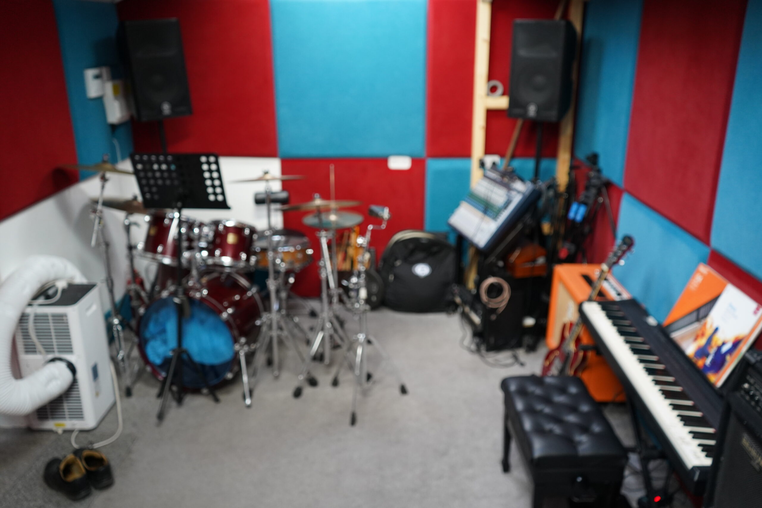 Full view of the acoustically treated rehearsal room, showing the drum kit, guitar and amp