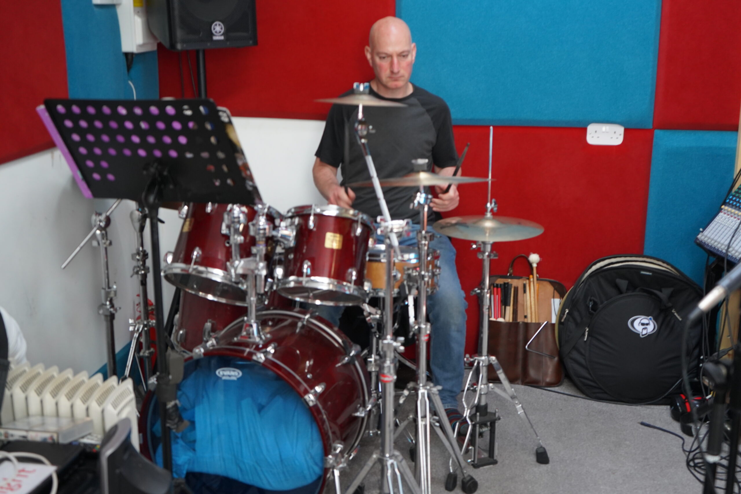 Musician playing the drum kit in the treated live room